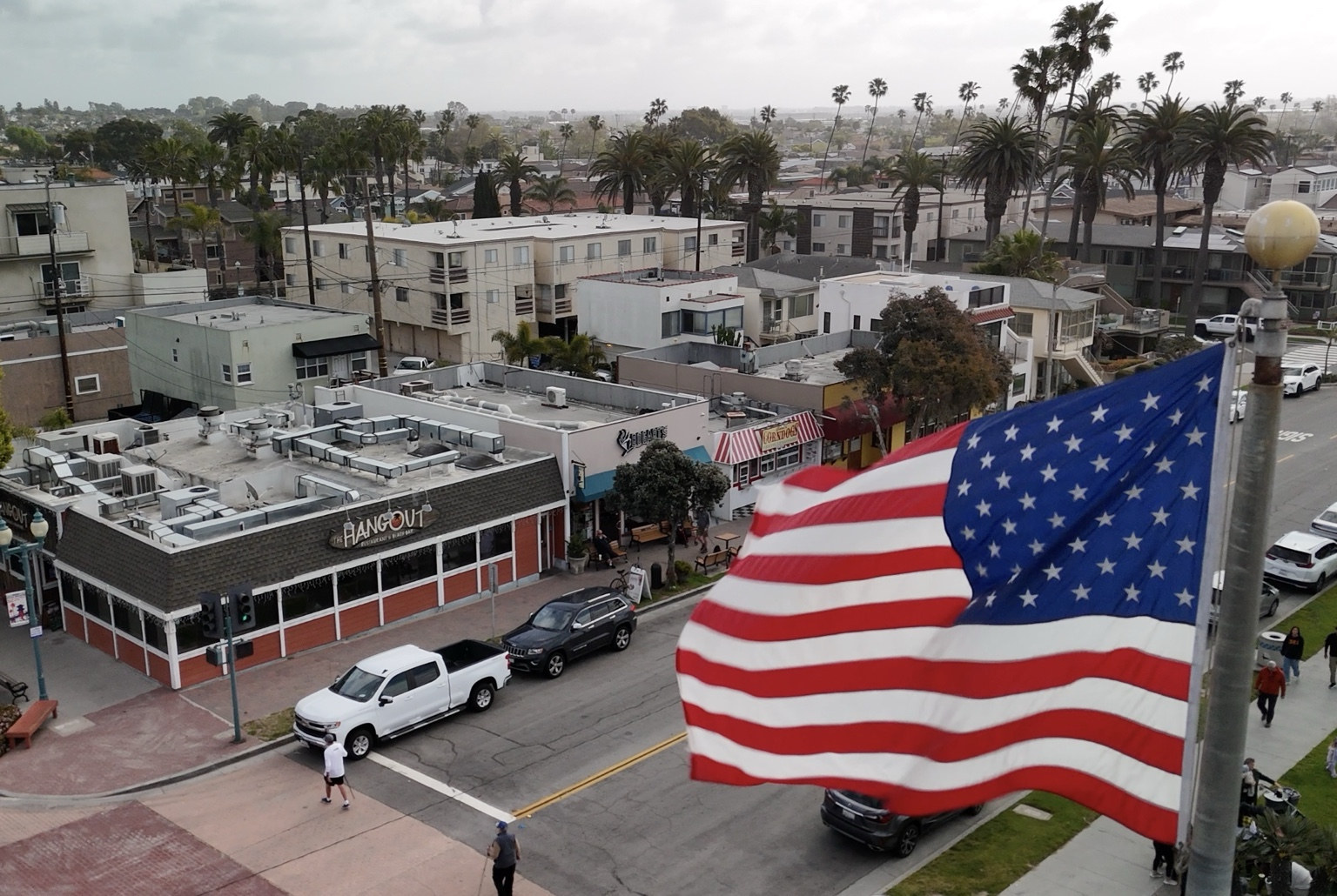 Southern California commercial district aerial with American flag